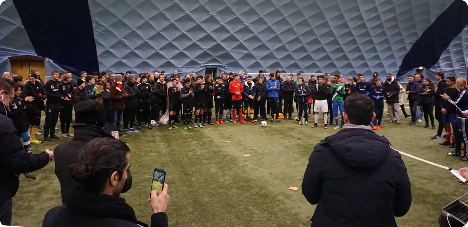 A large group test session in an indoor football dome